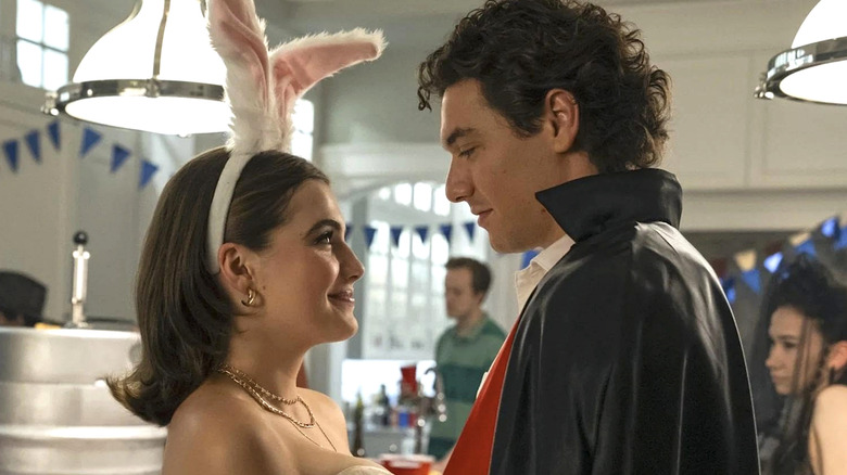 Hannah wearing white bunny ears and jewelry facing Garrett wearing a black cloak in 