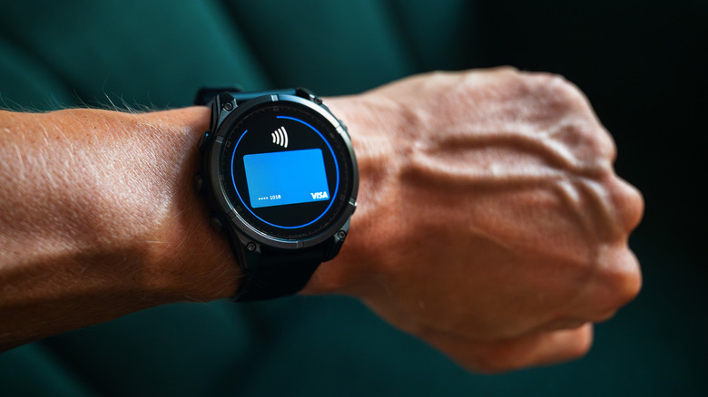 Garmin Fenix 8 smart watch enables seamless Visa payment via Garmin Pay, close-up editorial shot.