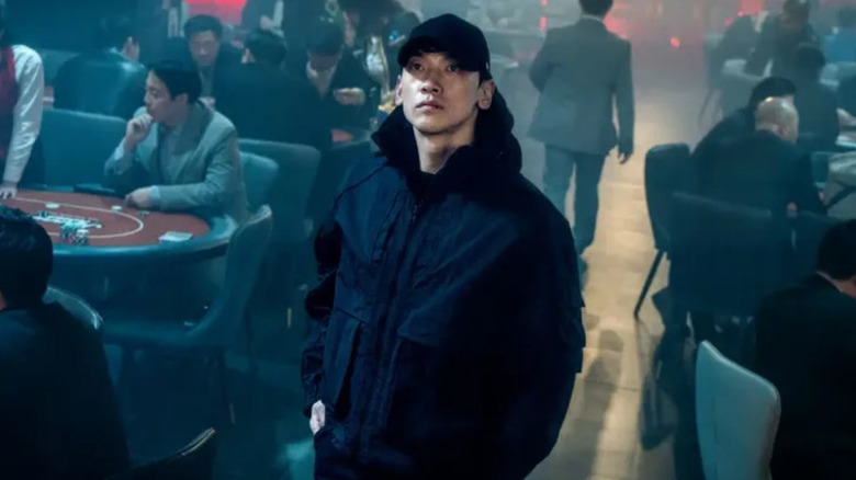 Seo Do-yoon looks up from a smoky casino floor in Red Swan