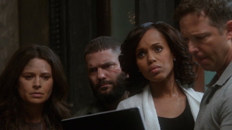 Kerry Washington as Olivia Pope holding tablet and looking up surrounded by coworkers on Scandal