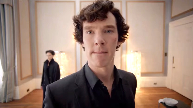 Sherlock Holmes (Benedict Cumberbatch) stands studying a wall in Sherlock