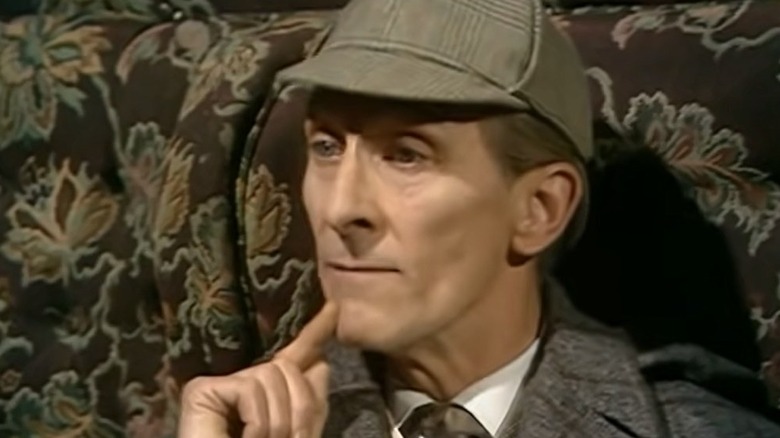 Sherlock Holmes (Peter Cushing) thoughtfully touches his chin in Sherlock Holmes (1965)