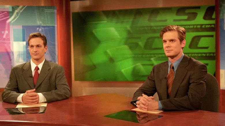 Josh Charles as Dan and Peter Krause as Casey sitting at TV news desk in Sports Night