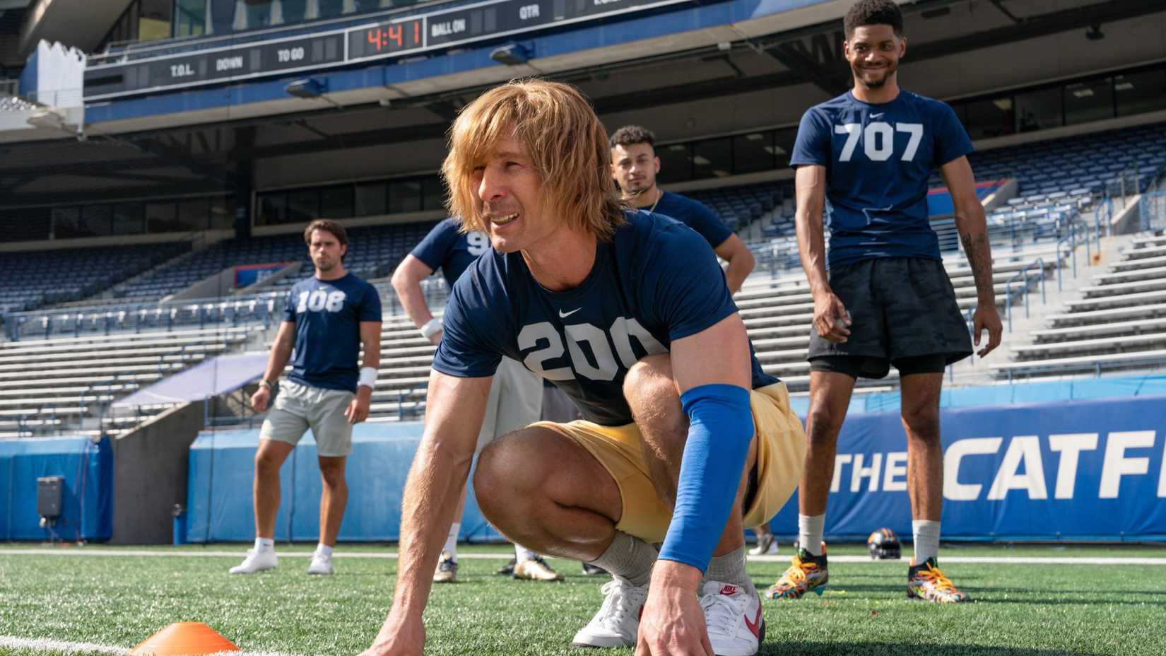 Chad Powers (Glen Powell) getting ready to run while the other players laugh in Chad Powers.