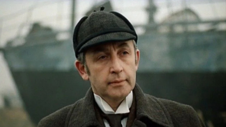 Sherlock Holmes (Vasily Livanov) stands near a large ship in The Adventures of Sherlock Holmes and Dr. Watson