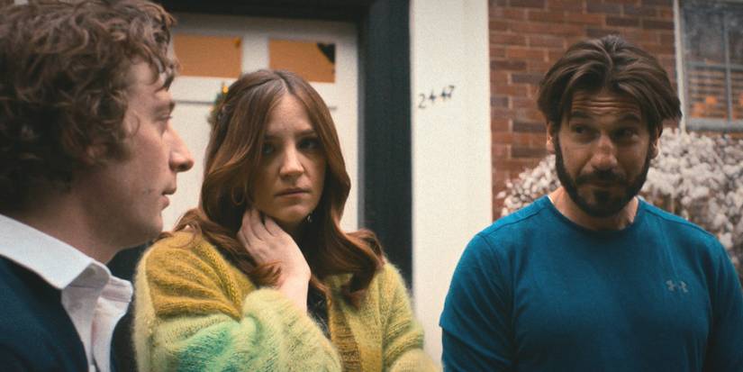 Mikey (Jon Bernthal) and Sugar (Abby Elliott) look at Carmy (Jeremy Allen White) in The Bear Season 2.