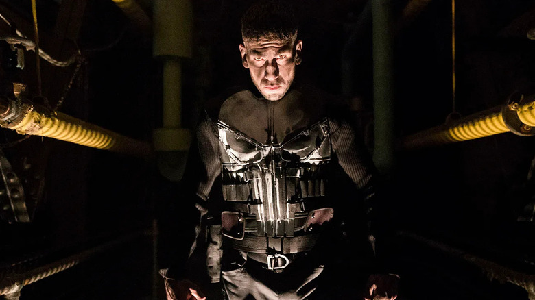 Frank Castle stands glaring in the shadows in The Punisher
