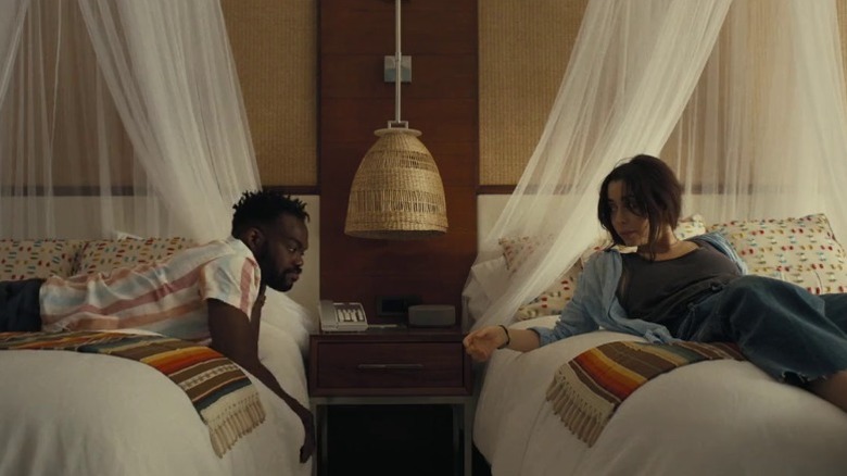 Noah (William Jackson Harper) and Emma (Cristin Milioti) lying on two beds in their room on The Resort S1E1