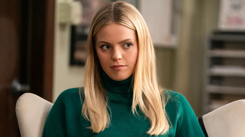 Renee Rapp as Leighton side-eyeing in a chair in The Sex Lives of College Girls