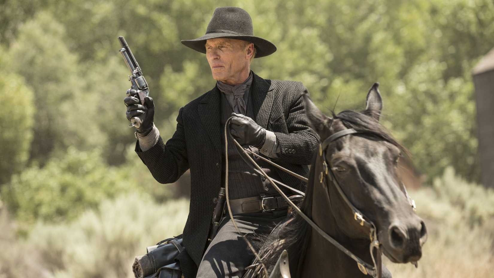 Ed Harris as Westworld's The Man in Black, riding a horse and holding a gun