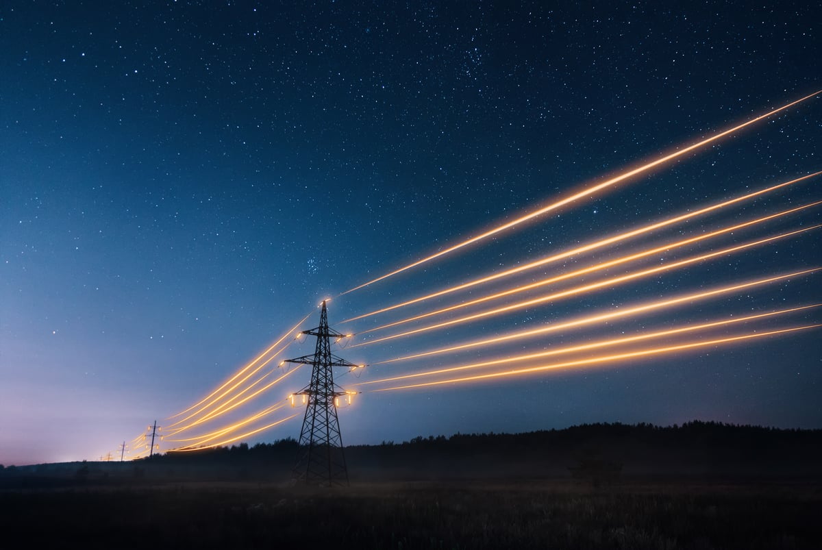 Lit-up power lines shine through the night.