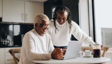 Smiling couple looking at laptop together.