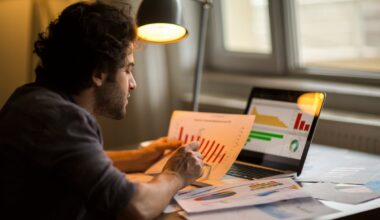 An investor holding a chart, comparing the data to numbers on a laptop.