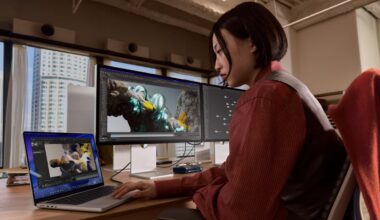 A woman working on a MacBook Pro, powering two high-resolution external displays.