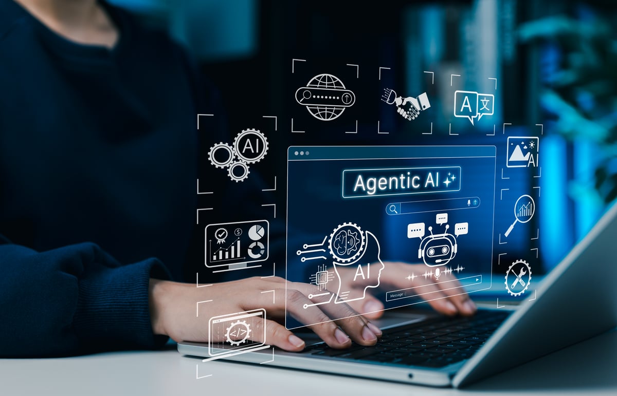 A graphic of agentic AI surfaces above a laptop.