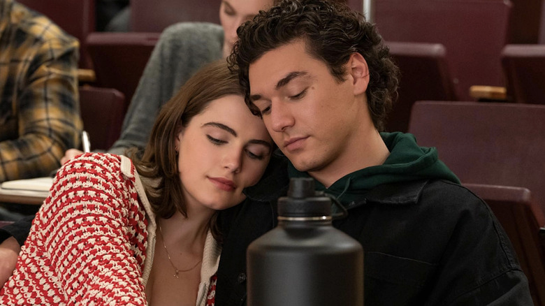 Hannah and Garrett sitting in a lecture hall together, staring down at a notebook
