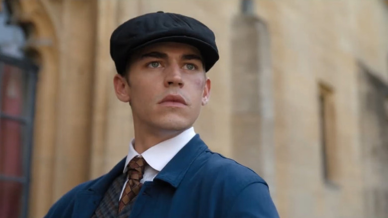 Sherlock Holmes (Hero Fiennes Tiffin) stands with a bruised cheek in Young Sherlock