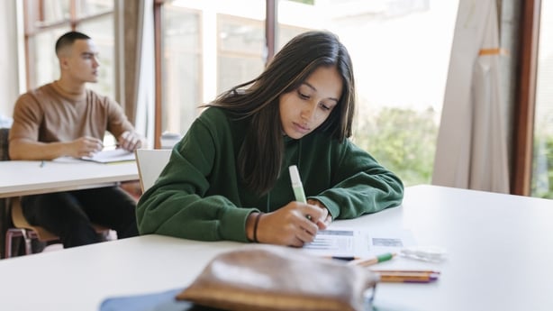 A high school student sitting at her desk concentrating during a test in class.