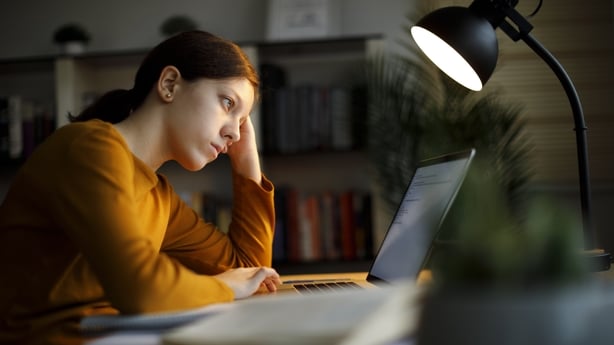 Worried teenage girl studying late at home