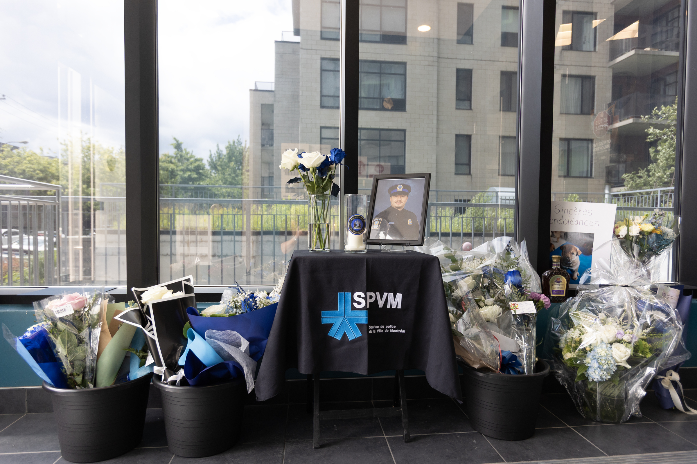 Photo of police offer on table surrounded by flowers 