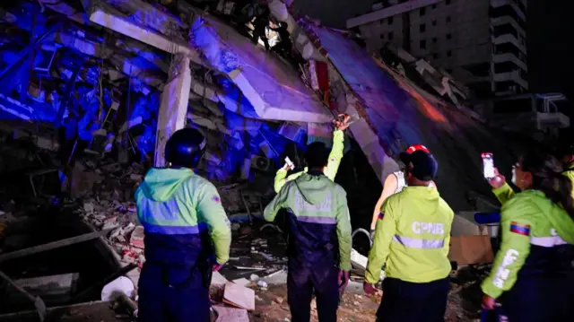 Emergency workers at a damaged building after an earthquake, in La Guaira, Venezuela