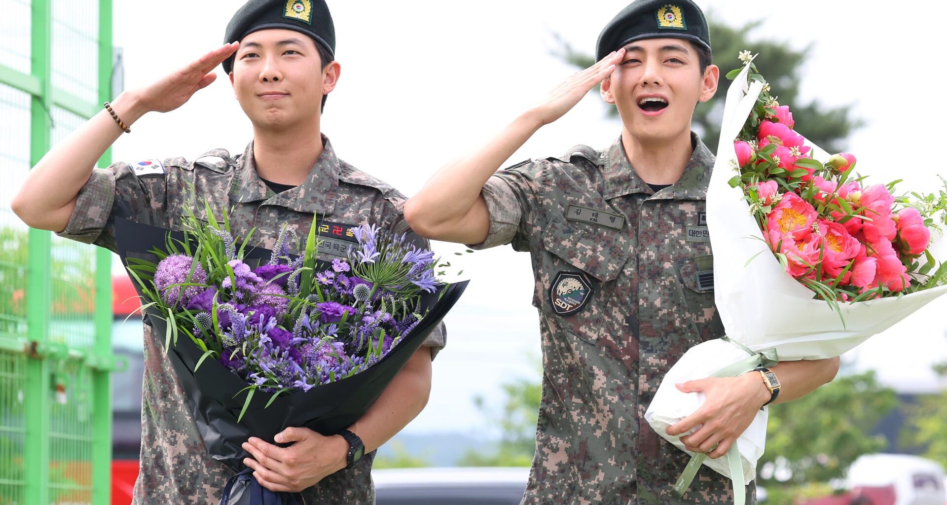 BTS members RM, left, and V salute after being discharged from the Army following their mandatory military service. Yonhap