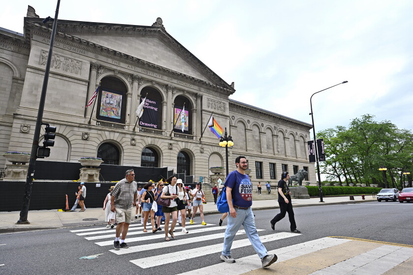 A group of people on a walking tour cross the street.