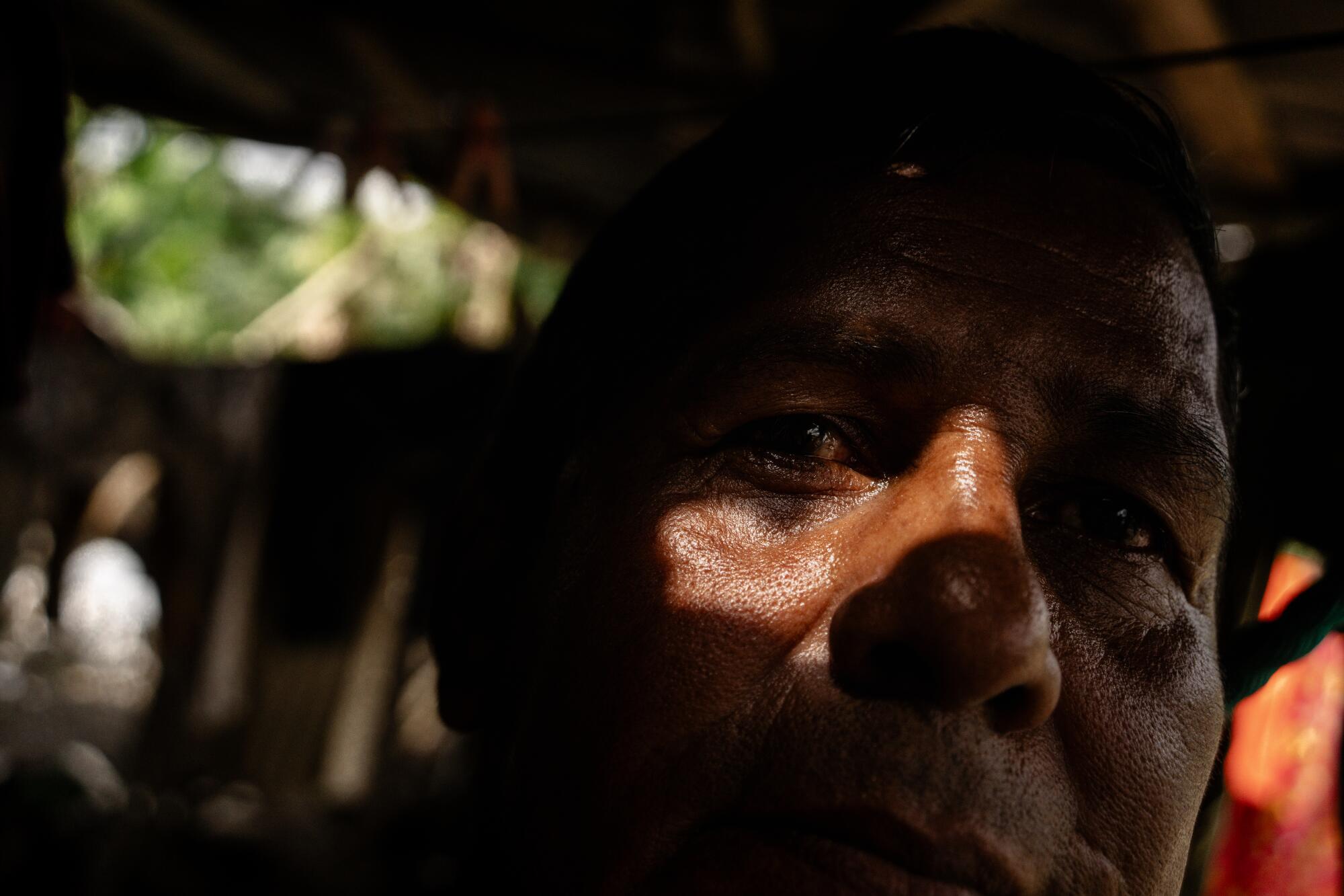 John Sebastian Palacios Vera, 54, poses for a portrait inside his home