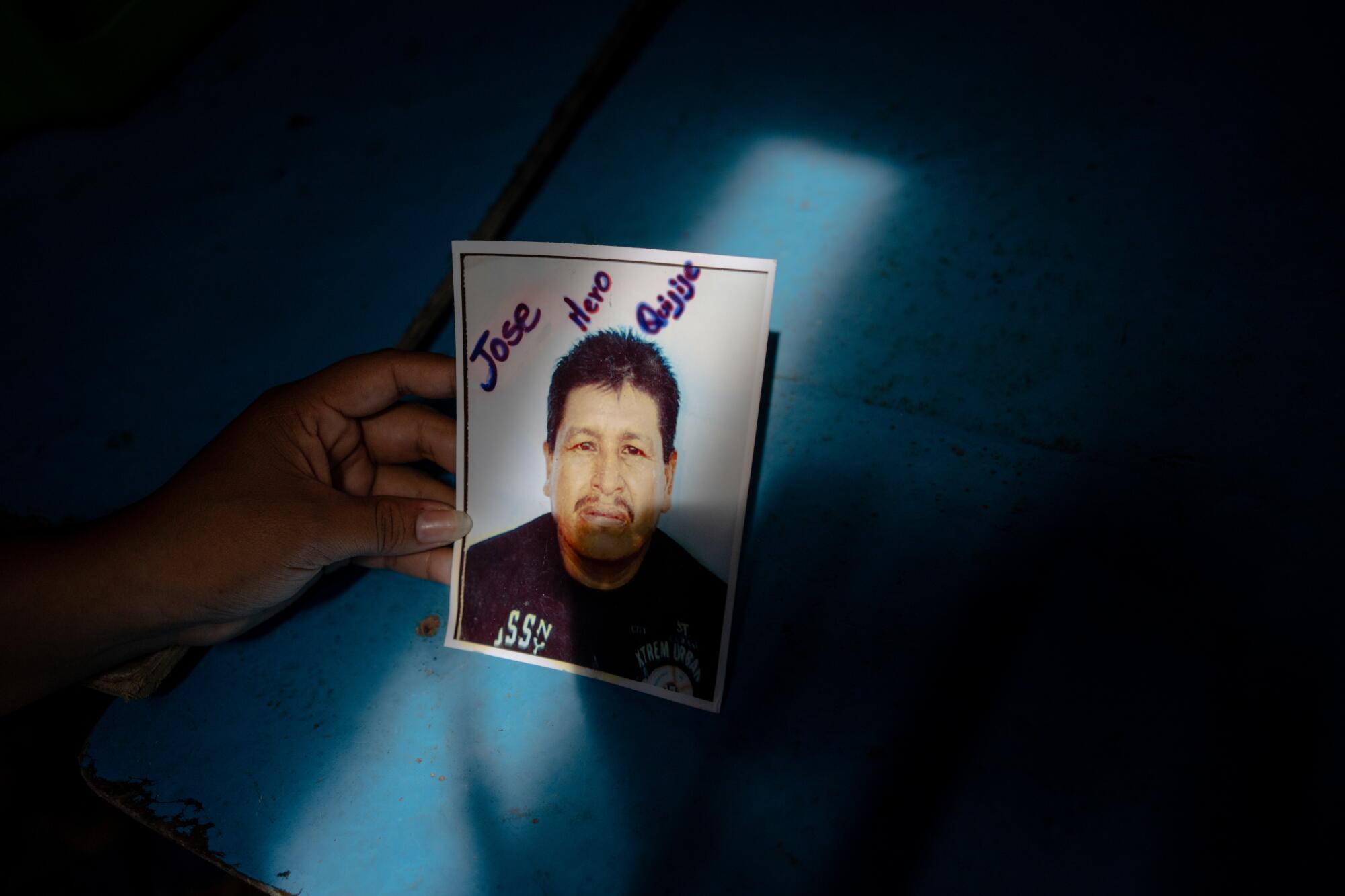Wendy Dayana Mero Bailon, 27, holds a photograph of her father,