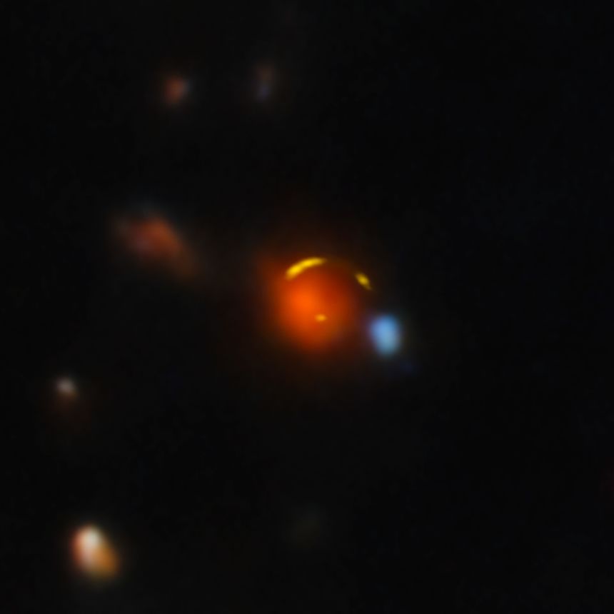 The red foreground galaxy bends the light of the more distant Shadow Blaster galaxy.