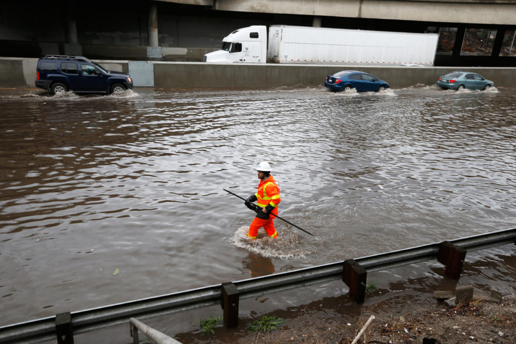 A worker wades through the flooded 5 freeway after El Nino-strengthened storm brought rain to Los Angeles