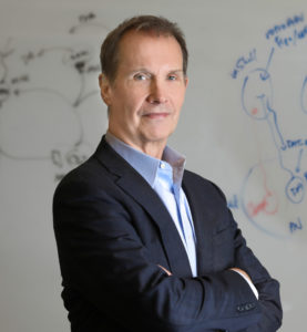 D. James Surmeier, PhD, the Nathan Smith Davis Professor and chair of Neuroscience, poses in front of a white board. 