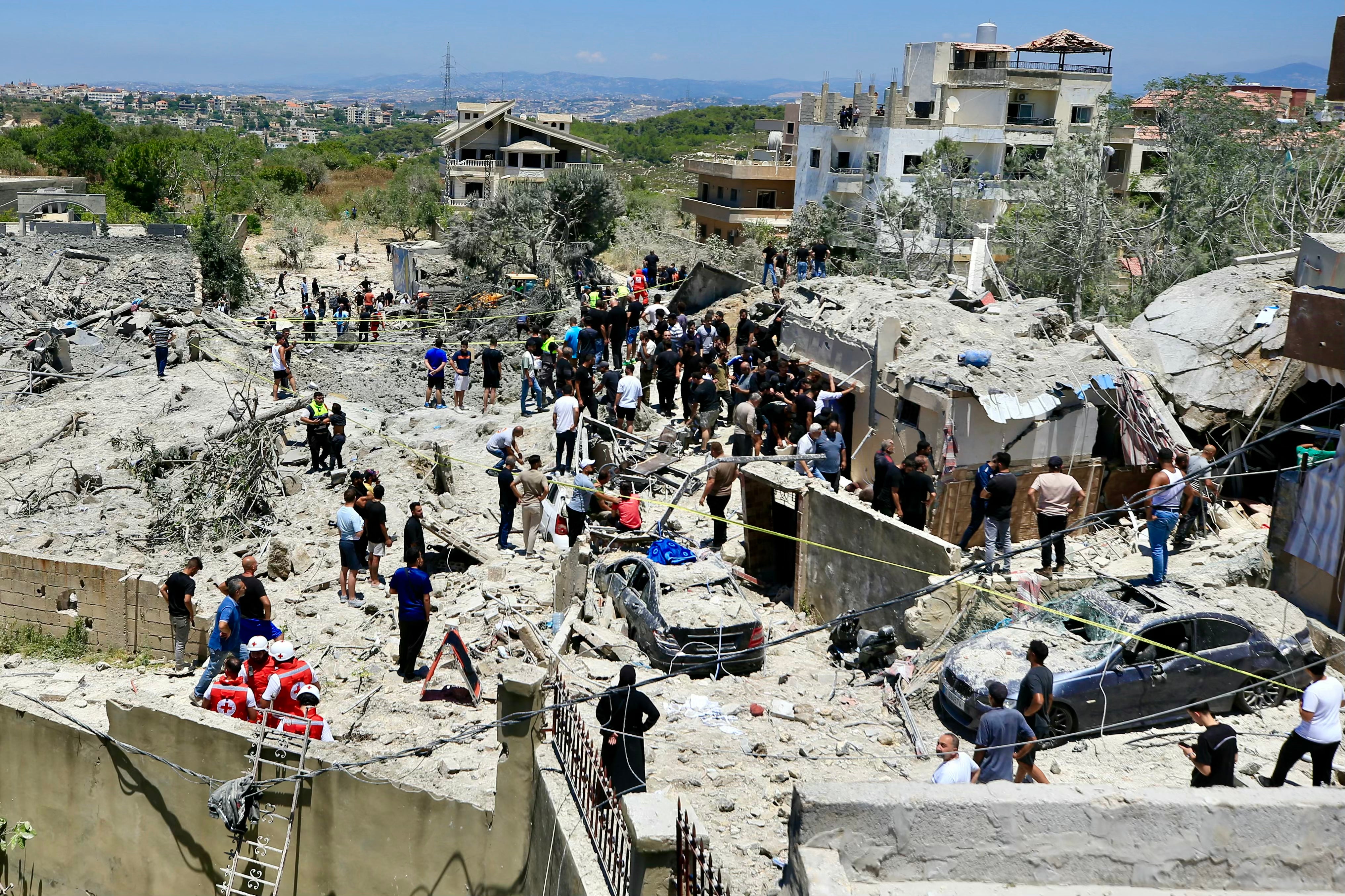 Civilians and first responders gather at the site of an Israeli airstrike that targeted the southern Lebanese village of Qennarit on Saturday