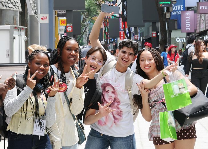 Foreign tourists  pose while visiting Myeong-dong,in central Seoul, June 9. Yonhap