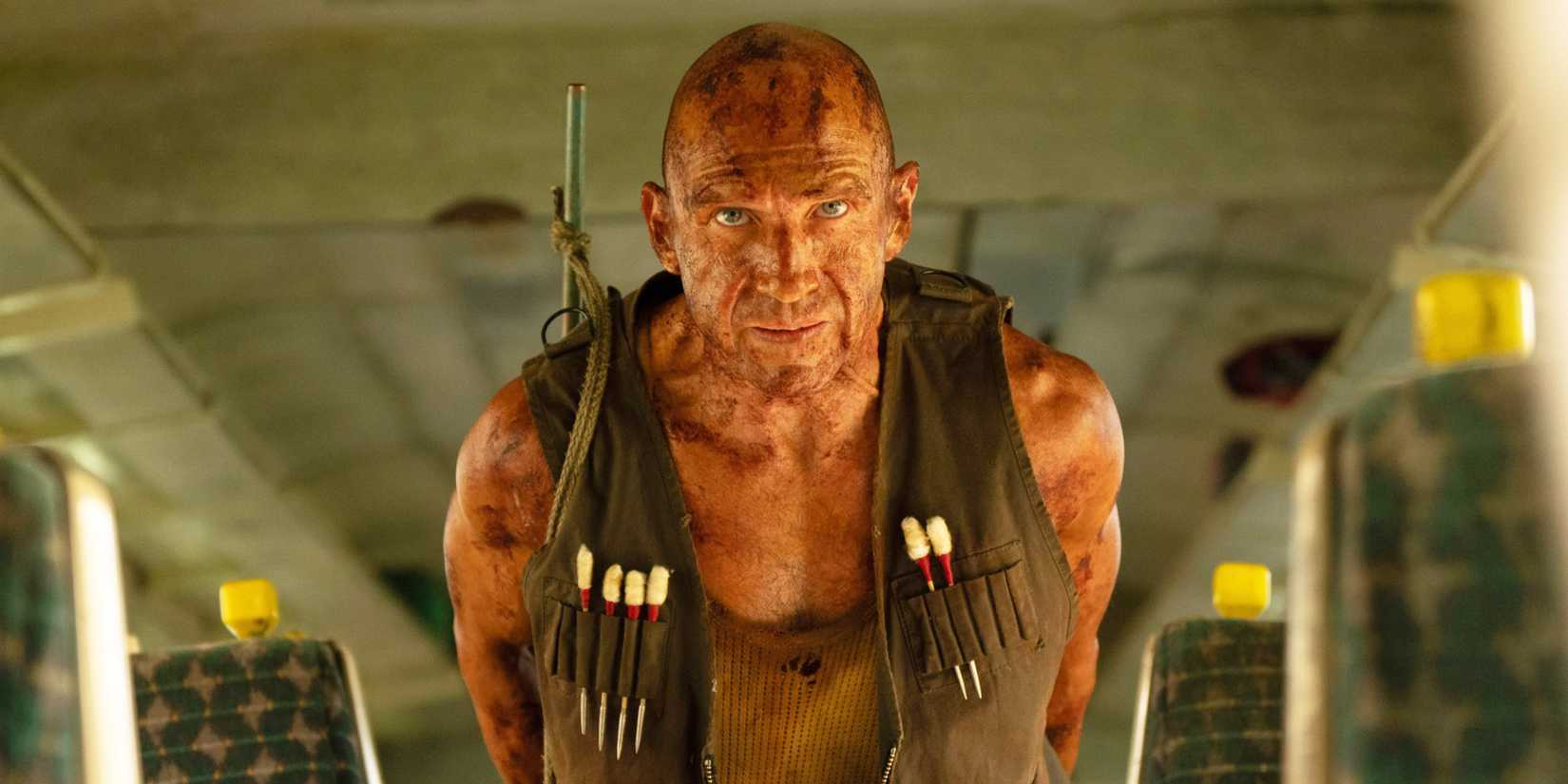 Ralph Fiennes in 28 Years Later: Bone Temple, walking cautiously through an empty bus