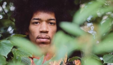 Jimi Hendrix, photographed peering out from behind a bush