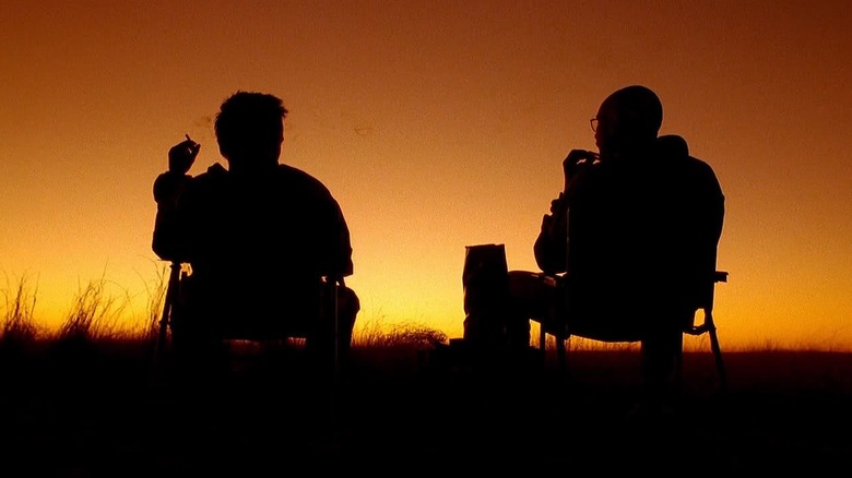 Aaron Paul and Bryan Cranston as Jesse and Walt sitting while silhouetted by the sunset in Breaking Bad