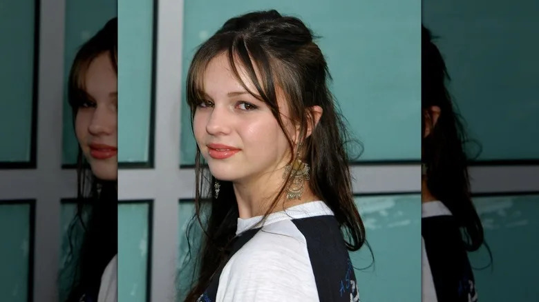 Young Amber Tamblyn smiles on a red carpet in 2003