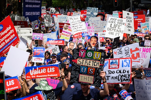 SYDNEY, AUSTRALIA - 2024/09/24: Protesters seen holding placards during the rally in front of the NSW Parliament. Nurses and midwives across New South Wales went on a 24-hour strike and marched from Hyde Park through Sydney's streets to NSW Parliament demanding a better pay rise. The association is calling for a 15% pay increase, while the government has only offered 3%. (Photo by George Chan/SOPA Images/LightRocket via Getty Images)