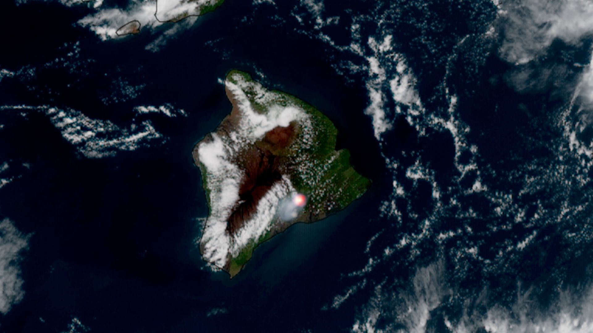 An image from space of an island with a bright red dot toward the bottom left.