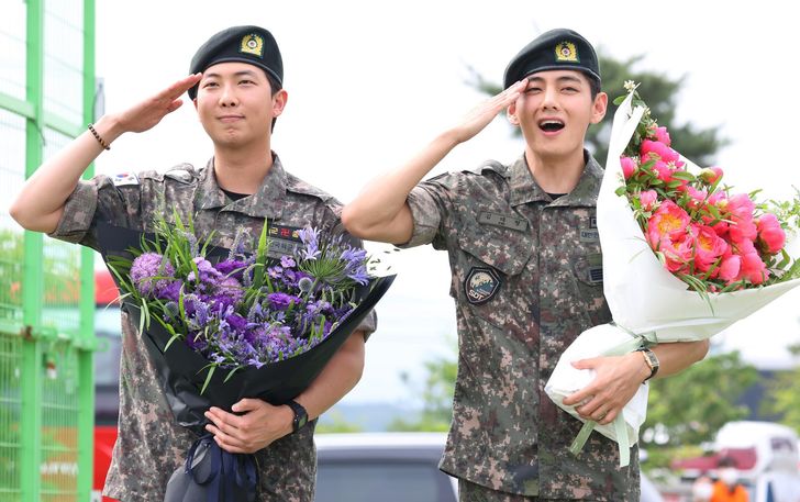 BTS members RM, left, and V salute after being discharged from the Army following their mandatory military service. Yonhap