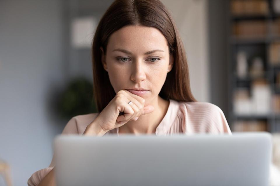 Person with intent look on their face, while looking at laptop.
