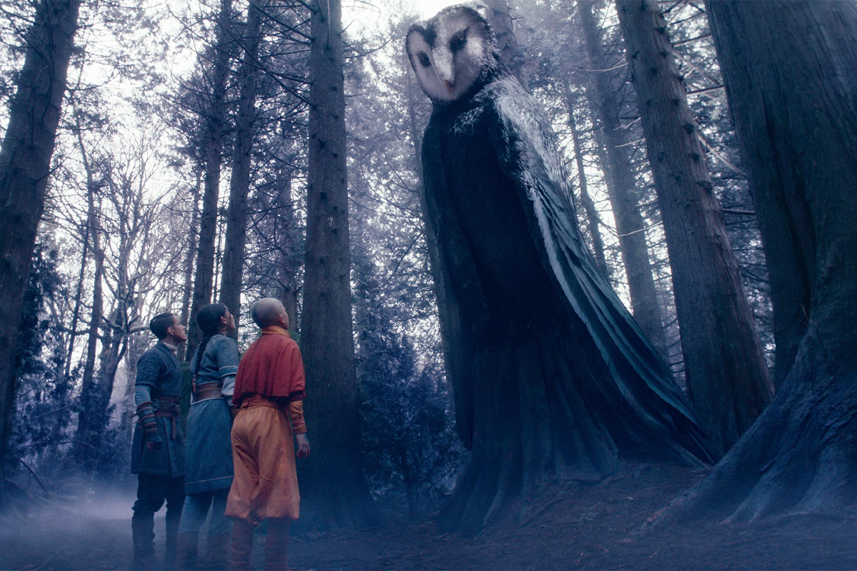 Three people in robes stand in a misty forest, looking up at a giant mystical creature, Wan Shi Tong, with the body of a robed spirit and the head of an owl among tall trees. The scene has a magical and mysterious atmosphere.