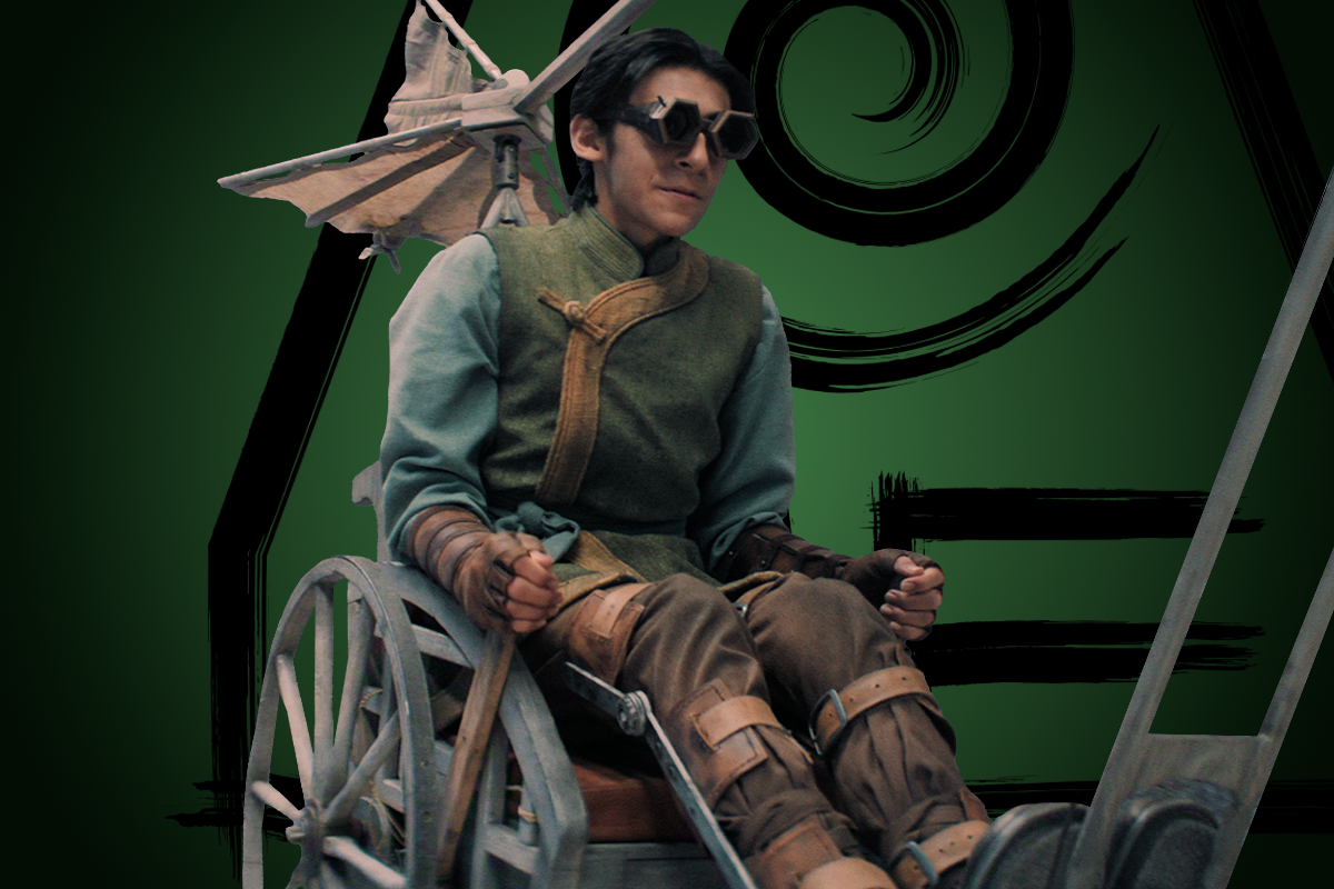 Lucian‑River Chauhan as Teo sitting in a mechanical wheelchair with wing-like attachments, set against a dark green abstract background with swirling black designs.