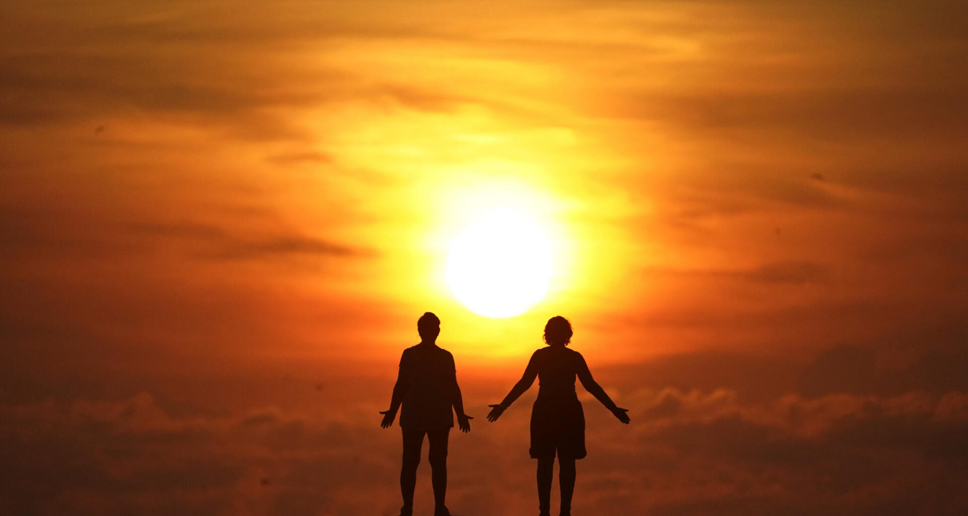 In this Sept. 19, 2020 file photo, two people greet the sun as they stand on a jetty while the sun rises over the Atlantic Ocean, in Bal Harbour, Fla. (Wilfredo Lee/AP)