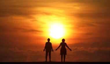 In this Sept. 19, 2020 file photo, two people greet the sun as they stand on a jetty while the sun rises over the Atlantic Ocean, in Bal Harbour, Fla. (Wilfredo Lee/AP)