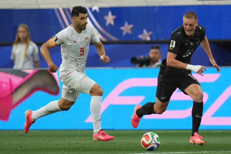 Iran's Mehdi Taremi (9) dribbles the ball against New Zealand's Finn Surman (16) during the World Cup Group G soccer match between Iran and New Zealand in Inglewood, Calif., near Los Angeles, Monday, June 15, 2026. (AP Photo/Andre Penner)