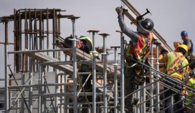 Workers on scaffolding at a construction site.