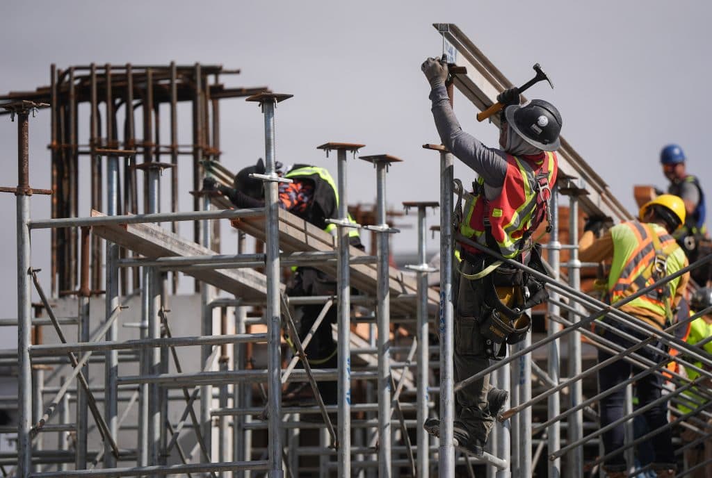 Workers on scaffolding at a construction site.