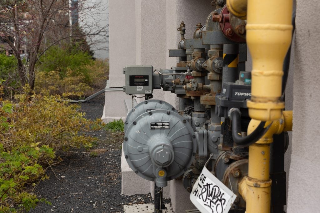 Natural gas meters installed on the exterior wall of a building.